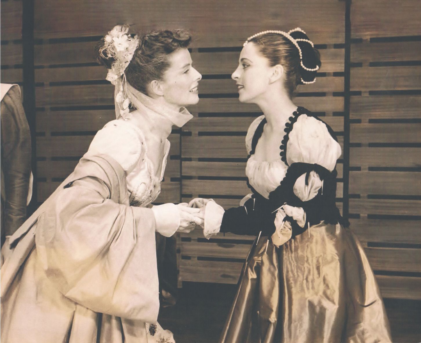 צילום בשחור לבן של דינה דורון משחקת בהצגה עם שחקנית נוספת ומחזיקות ידיים 